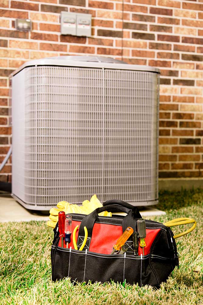 ac unit and tool bag in the grass